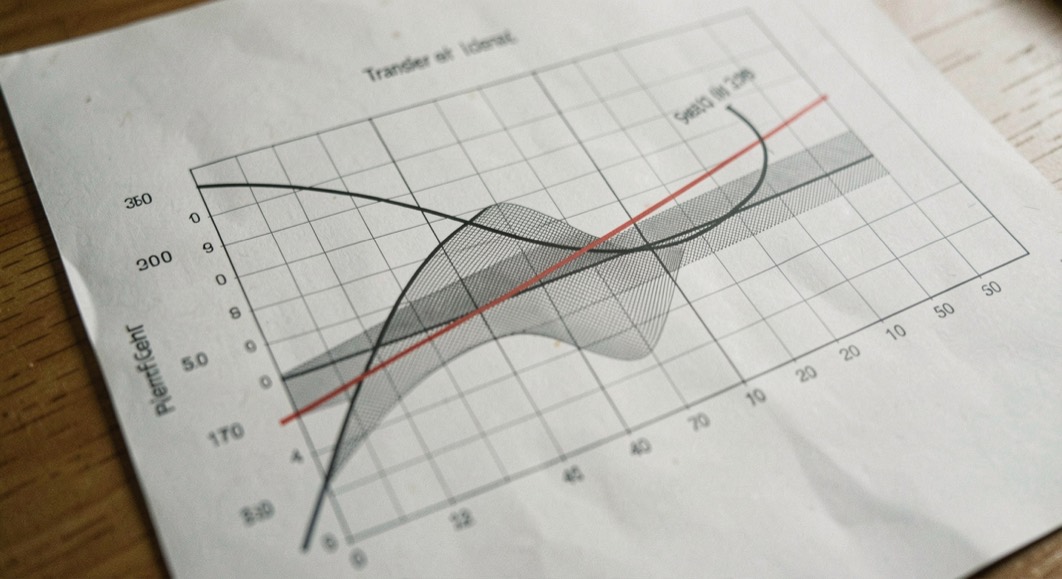 A printed transfer curve on a logarithmic grid with the ideal straight line drawn over it in red and the deviation shaded between the two